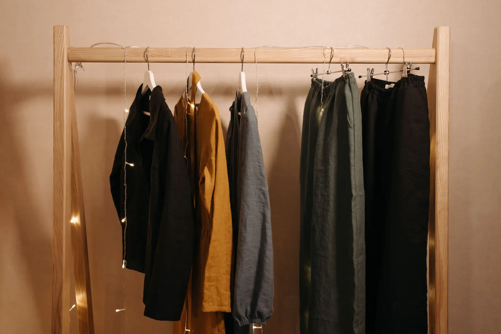 木のラックに掛けたリネンの服（イメージ写真）